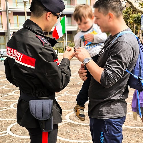Il Capitano regala una bandiera dell'Italia a un bambino